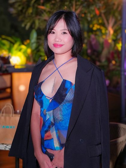 A guest posing in the beautifully lit outdoor area of TYD.