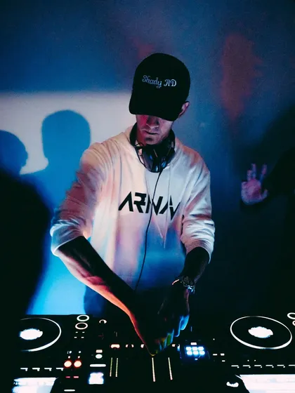 A portrait from behind the decks before a big show, ready to deliver a powerful Afro-Bolly and Tech House experience.