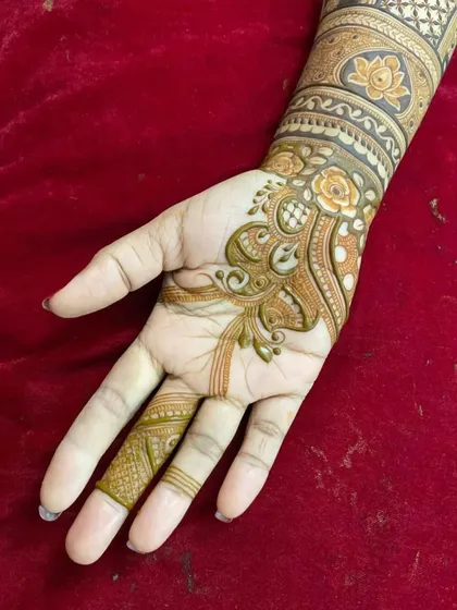A detailed look at the palm work for a floral design. The delicate lines and shading create a beautiful, flowing pattern that complements the armbands.