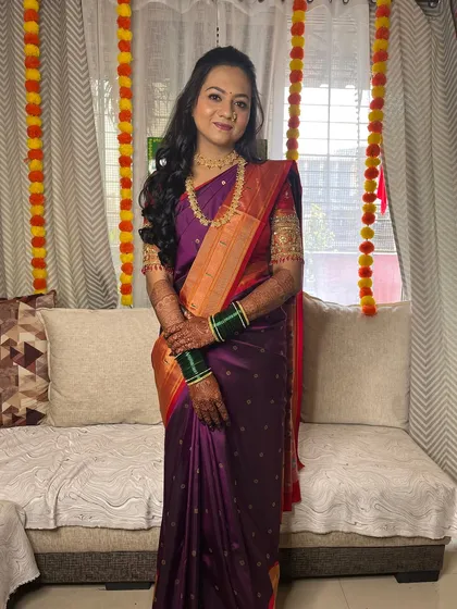 The full look, showing the elegant drape of her purple and orange saree.