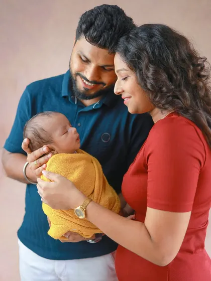 A family admiring their newest member. Using a simple, warm-toned backdrop keeps the focus entirely on the emotional connection and love you all share.