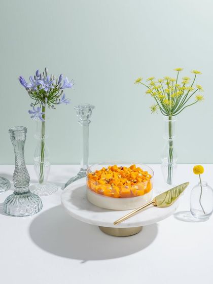 A mango panna cotta, beautifully presented among fresh flowers.