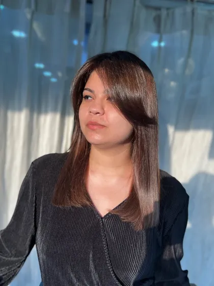 This client is glowing in the sunlight with her new hair. We created a warm, light brown look with face-framing layers for a fresh and modern style.