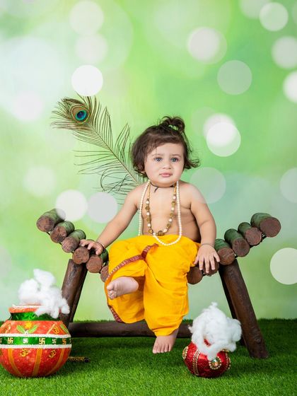 A playful moment captured during a Krishna-themed shoot. This little one looks like he's about to share a secret.