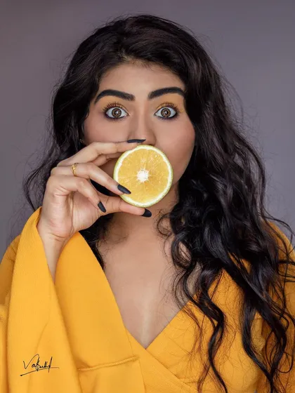 The full-color version of our creative orange slice portrait. The bright yellow of the model's top and the orange itself create a vibrant, energetic photo that is full of personality.