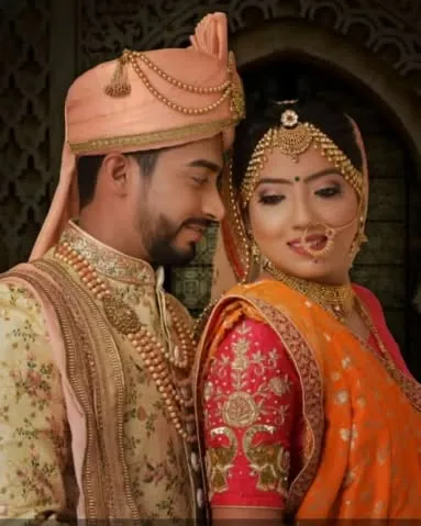 A classic wedding portrait. The groom admires his bride, whose makeup is soft and romantic, perfect for this intimate moment.