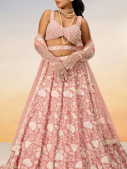 Another view of the pastel pink lehenga, this time with elegant gloves, showing how you can style it for a unique look.