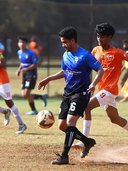 A player shields the ball from an opponent during a tough MFA Third Division match against Mumbai Strikers.
