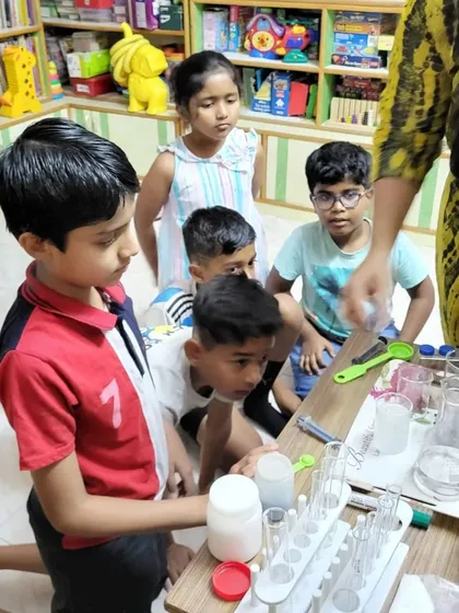 I love seeing kids this focused and curious. Here, a group is gathered around the table, carefully observing a chemical reaction. My goal is to create these moments where they are completely absorbed in the process of discovery.