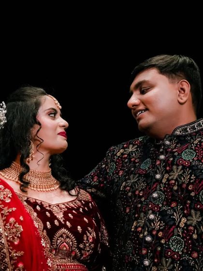 A romantic gaze between the couple, captured against a dark background to emphasize their connection.