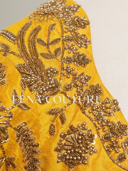 This sunshine yellow raw silk blouse is brought to life with meticulous hand embroidery by my talented artisans. The dense, traditional motifs in antique gold threadwork cover the back and sleeves, creating a piece that radiates warmth and luxury.