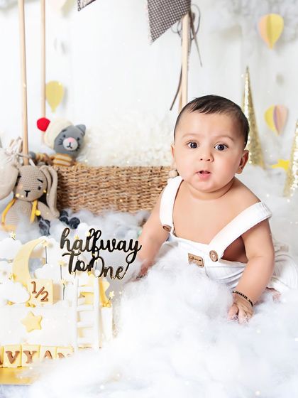 Six months of sweetness. This little one is all smiles next to his "halfway to one" cake in our dreamy cloud and hot air balloon setup.