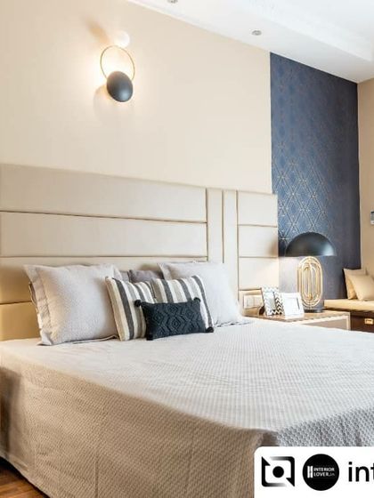 Another view of the guest bedroom, showing the bay window seating and the subtle geometric wallpaper that adds a layer of interest to the serene design.