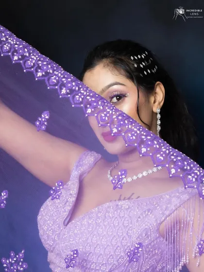 For this lilac lehenga, I created a look with complementary purple and pink tones on the eyes. This shot, with the veil, adds a touch of mystery and highlights the intricate glitter work on the eyelids.