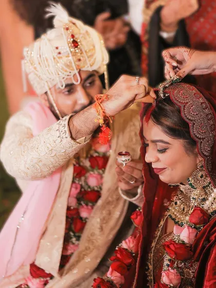 A close-up of the wedding rituals, showing the groom performing a traditional ceremony for his bride. This image is rich with cultural significance and emotion.