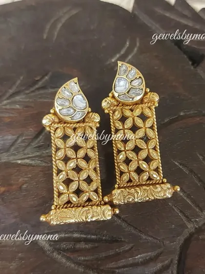 These Dakshinaya earrings showcase a beautiful contrast between the uncut polki stone and the detailed gold lattice work, creating a piece that is both rustic and refined.