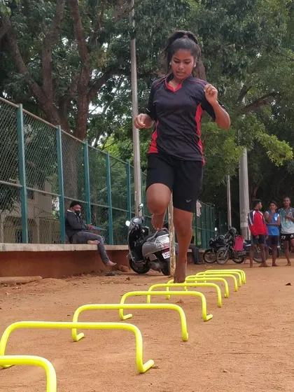 Look at the focus and power. This is one of our female athletes mastering a hurdle drill to improve her footwork and speed. We train our athletes to be explosive and agile, which is crucial for competitive sports.