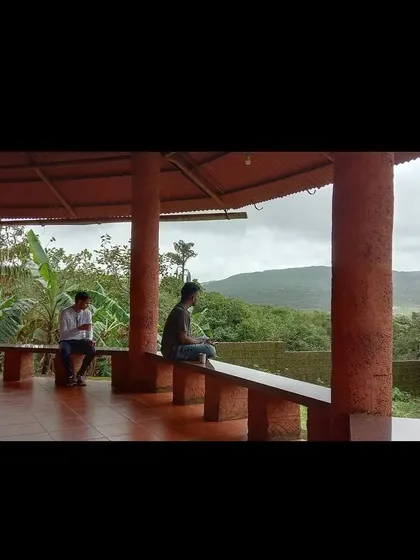 Students enjoying a quiet moment on the veranda, looking out at the green landscape of Amboli. There is ample time for personal space and reflection during our courses.