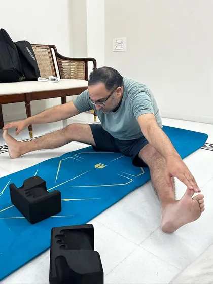 A seated wide-legged forward fold. This stretch is excellent for the hamstrings and inner thighs, and we modify it to be gentle on the joints.