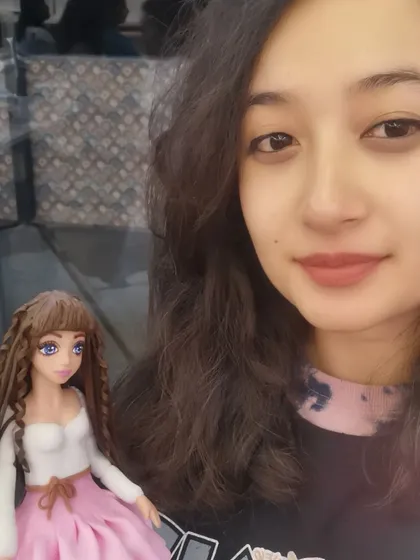 Here I am with the doll figurine I made during my masterclass. Every detail, from her hair to her dress, is crafted from sugar. This was a huge learning curve for me, and I'm so proud of how she turned out.