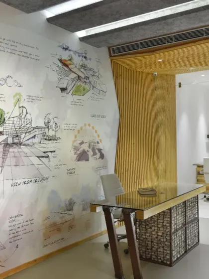 The reception area of the AMG office, where a large wall mural of conceptual sketches greets visitors. This element immediately communicates the design-driven nature of the real estate firm.