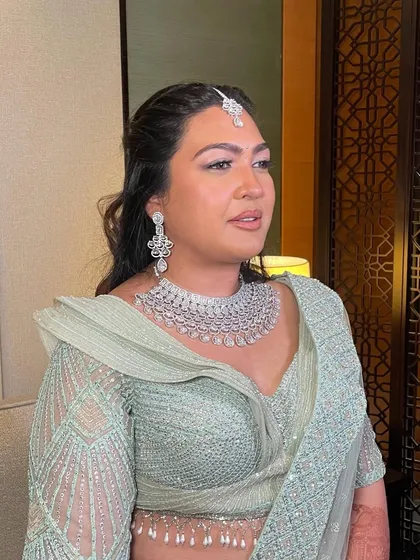 A front view of the client, her hairstyle perfectly complementing her pastel lehenga.
