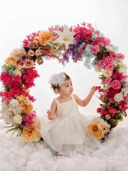 A moment of curiosity as this little one reaches out to touch a flower on the beautiful, multi-colored wreath.