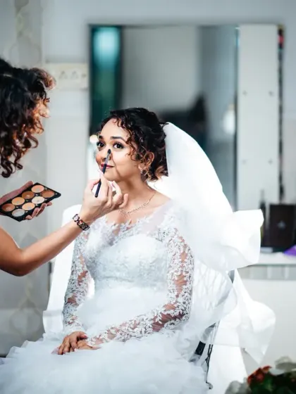 The bride gets her makeup done, looking calm and beautiful before the ceremony.