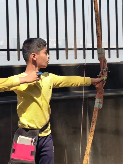 A young boy shooting with the sea in the background. Our Dadar location offers a unique and beautiful setting for practice.