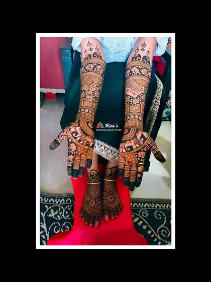 The complete bridal mehendi for a South Indian wedding, with coordinated designs on the hands and feet. The patterns are intricate and full, perfect for a bride.