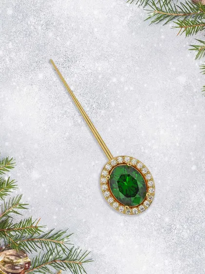This handcrafted pin highlights a stunning green emerald, embodying nature’s charm and accented with brilliant diamonds. A perfect festive touch.