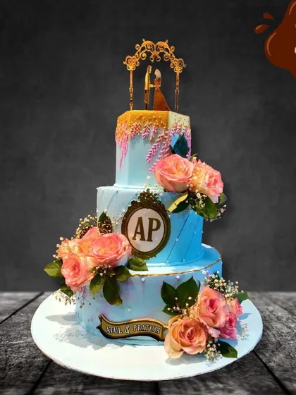 For this three-tier engagement cake, I used a soft blue buttercream and adorned it with fresh peach roses and a custom monogram. The gold drip and elegant topper add a touch of luxury to celebrate the couple's new beginning.