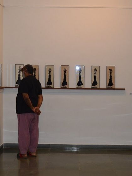 Visitors admiring the series of works on the wall.