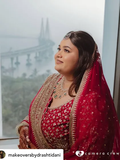 This stunning shot captures the bride against the Mumbai skyline. Her makeup is perfectly set to look flawless both indoors and out, with a timeless elegance befitting the location.