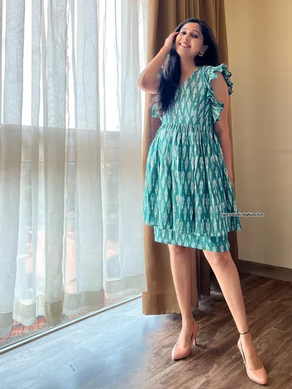 Another look at the sea-green Ikat ruffle dress, showing its flattering fit and flare. It’s a testament to how traditional fabrics can be used in contemporary western styles.