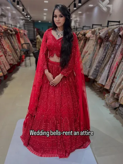 A full look at this fiery red lehenga with cape-style sleeves. It's a modern, powerful, and glamorous outfit available for you to rent and rock.