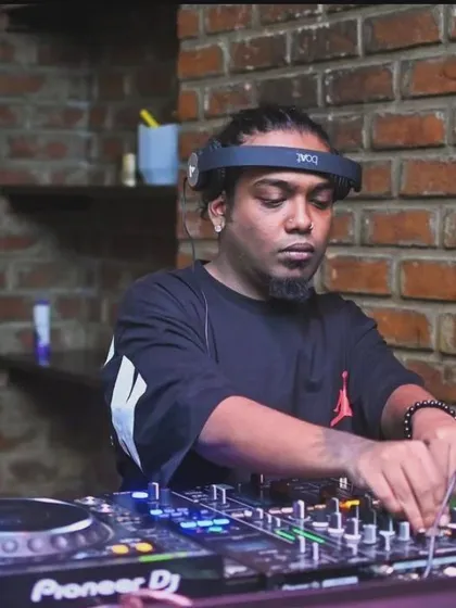 In the zone, spinning a hip-hop set. The brick wall background gives this spot a raw, urban feel.