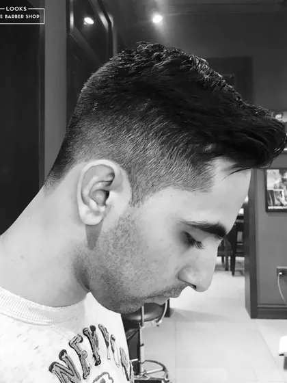 A close-up on a mid-fade, showcasing the clean lines and meticulous detail around the ear. Precision is our promise.
