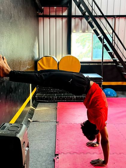 Another student practices the wall-assisted backbend, showing that this drill is a staple in our adult classes.