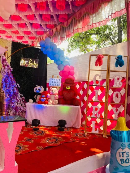 A gender reveal corner at a baby shower with colorful teddy bears and marquee letters.