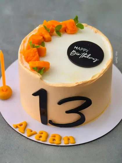 A simple and refreshing Mango Vanilla cake for a 13th birthday. The cake is decorated with fresh mango chunks in a crescent shape.