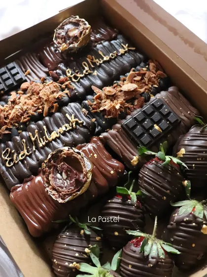 A decadent "Eid Mubarak" dessert box filled with chocolate-covered treats and chocolate-dipped strawberries.