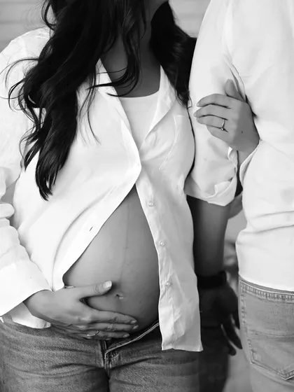 A close-up, artistic shot in black and white focusing on the baby bump, highlighting the beauty of pregnancy.