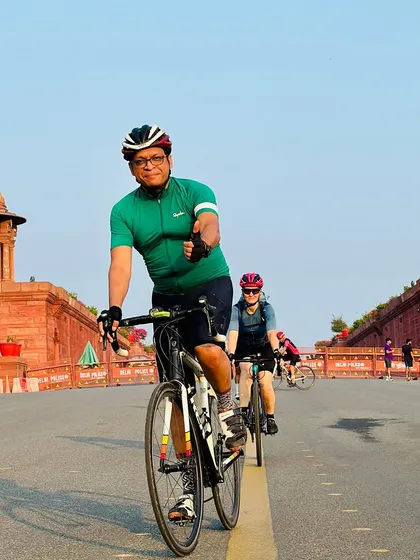 A rider giving a thumbs-up as he rides towards the camera on the iconic Vijay Chowk road.