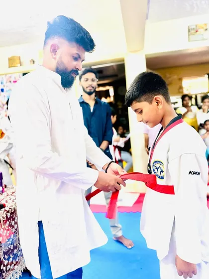 A proud moment for this young student, earning his red belt.