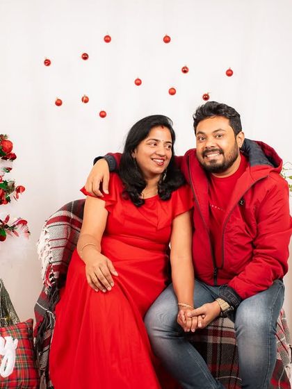A cozy and happy couple's portrait from a Christmas-themed shoot. The warm blanket and festive decor create a perfect holiday atmosphere.