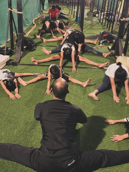 Our coach leads the class in a full middle split, demonstrating the incredible flexibility that can be achieved with consistent practice.