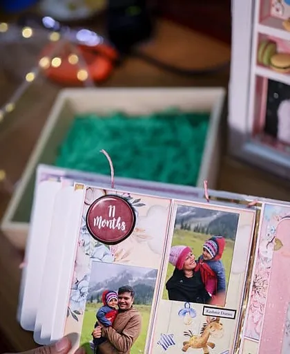 A peek inside the album, showing the '11 months' page filled with sweet family photos.