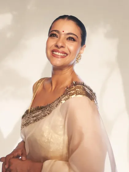 The joy and radiance of the moment are captured perfectly in this shot, highlighting the dreamy quality of the white and gold saree.