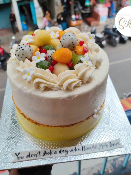 A beautiful fresh fruit cake topped with a mix of seasonal delights like dragon fruit, melon, and pomegranate. A healthy and delicious option for any celebration.